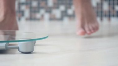 Erkek ayak banyo üzerinde kilo kontrolü için elektronik teraziler tutuyoruz. Yakın çekim . 