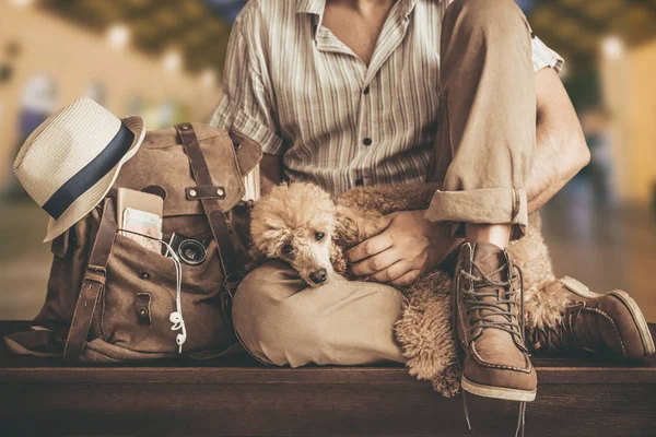 Young man with dog and backpack . Concept of travel.
