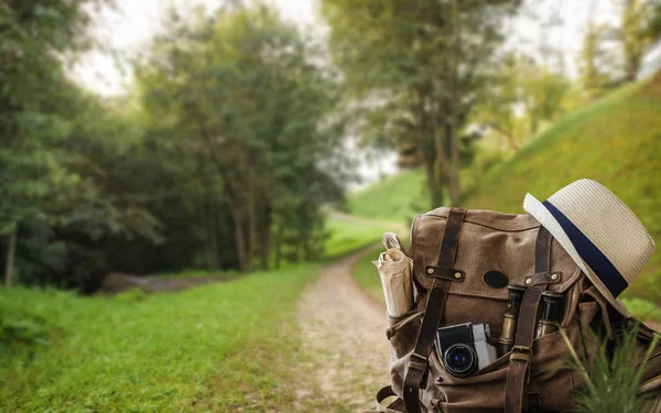 Looking image of travelling concept, essential vacation items. Background of mountain.