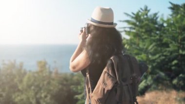 Sırt çantası ile mutlu kadın turist. Seyahat ederken retro kamerayla resim yapma kadın .