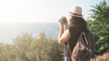 Sırt çantası ile mutlu kadın turist. Seyahat ederken retro kamerayla resim yapma kadın .