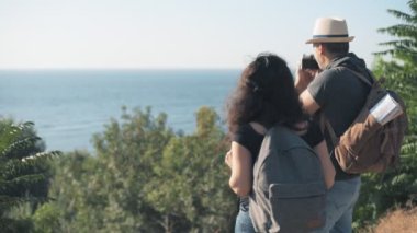 Mutlu çift turistlerle sırt çantaları. Adam seyahat ederken retro kamerayla resim yapma . 