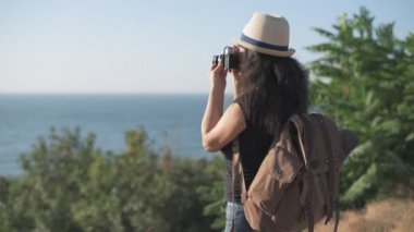 Cinemagraph-mutlu kadın turist sırt çantası ile. Seyahat ederken retro kamerayla resim yapma kadın. Hareketli fotoğraf.