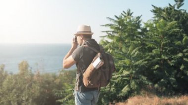 Sırt çantası ile mutlu erkek turist. Adam seyahat ederken retro kamerayla resim yapma .