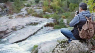 Seyahat ederken bir kamerayla resim yapma adamım. Doğal Kanyon dağ nehir manzarasına sahip. Seyahat kavramı.