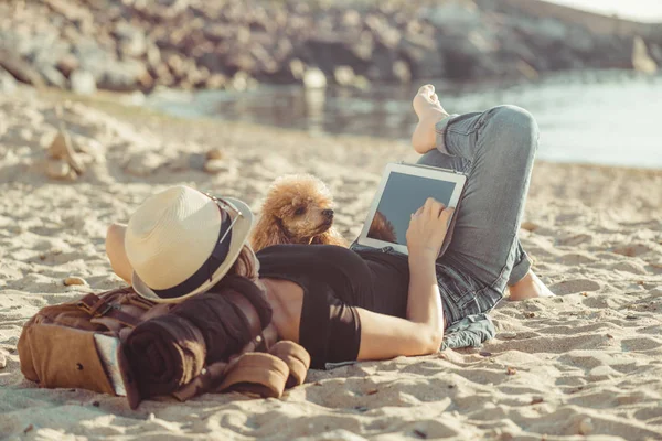 女人旅行者手持触摸垫 而在他的海上旅行中放松户外 女人和她的狗一起旅行 — 图库照片