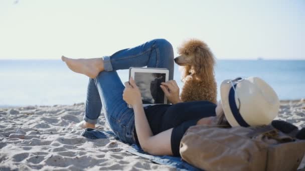 女性旅行者がタッチを保持しているパッドは しばらくの間 海で彼の旅行中に屋外でリラックスしました 女性は彼女の犬と旅行します — ストック動画