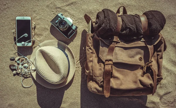Looking image of travelling concept, essential vacation items. Background of sandy. Close-up.