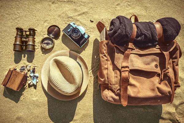 Looking image of travelling concept, essential vacation items. Background of sandy. Retro effect. Close-up.