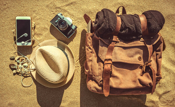 Looking image of travelling concept, essential vacation items. Background of sandy.  Close-up.