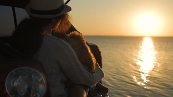 妇女旅行者与狗坐在汽车树干附近的海 看日落 — 图库视频影像