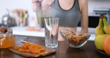 Genç kadın içme güler yüzlü bir çalışmadan sonra ev mutfak.