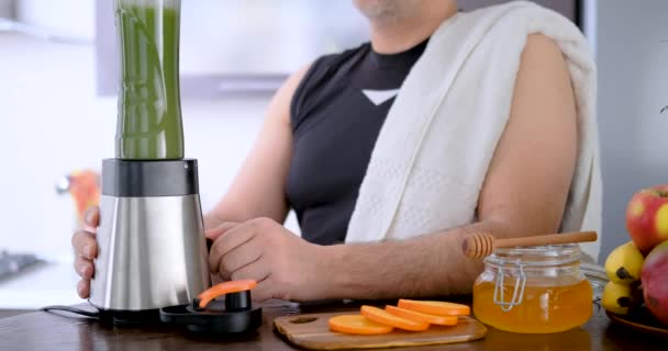 成人男子在家庭厨房锻炼后用果汁机制作绿色果汁 — 图库视频影像