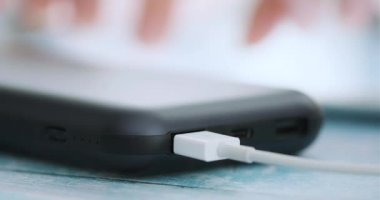 Güç bankaya şarj ederken akıllı telefon kullanan kadın. Portre.