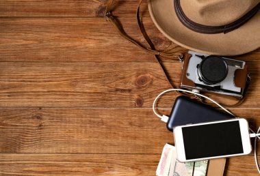 Hareket eden telefon ile powerbank ahşap masa arka plan üzerinde. Görüntü kavramı seyahat seyir.