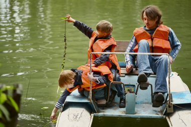 Baba ve iki oğlu üzerinde Nehri boyunca pedal katamaran yelken. Herkesin can yelekleri var.