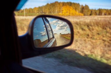 Dikiz aynası aracılığıyla bir ülke yolunun görünümü