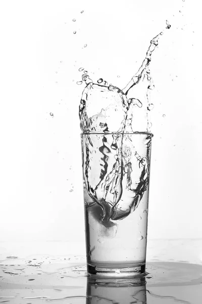 Salpicadura de agua en un vaso de precipitados. Fondo blanco . —  Fotos de Stock