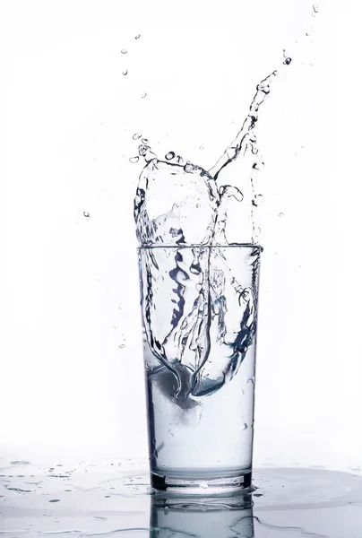 Salpicadura de agua en un vaso de precipitados. Fondo blanco . —  Fotos de Stock