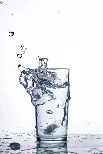 Salpicadura de agua en un vaso de precipitados. Fondo blanco —  Fotos de Stock