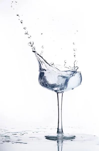 Salpicadura de agua en una copa de champán. Fondo blanco . —  Fotos de Stock