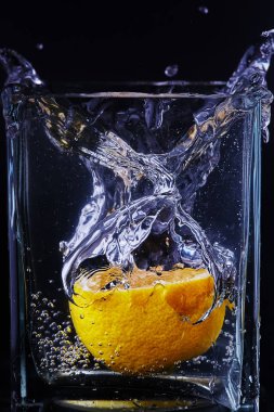 Cam bir kapta bir parça limon. Siyah arka plan