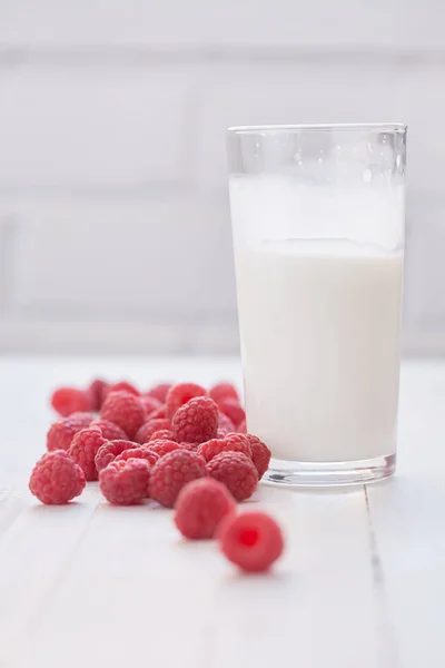 Un vaso de leche y frambuesas maduras. Fondo blanco . —  Fotos de Stock