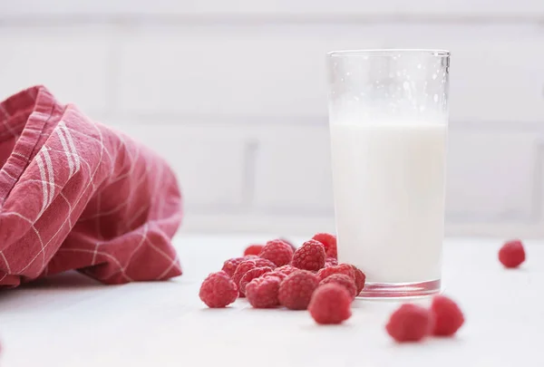 Glass of milk and ripe raspberries. White background. — Stock Photo, Image