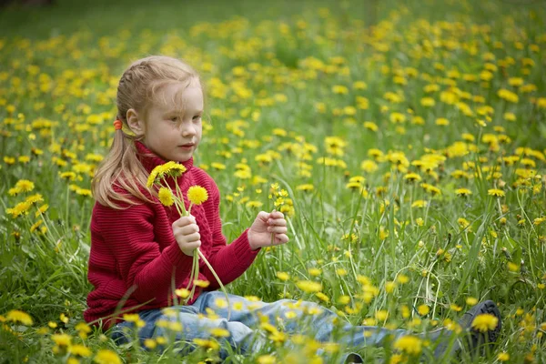 Niña y prado con dientes de león. Día de verano al aire libre — Foto de Stock