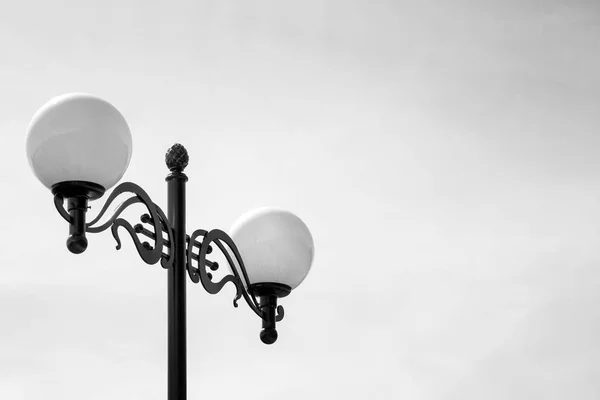 Two Street Lamps on Black Lamp Stand. Black and White Photo