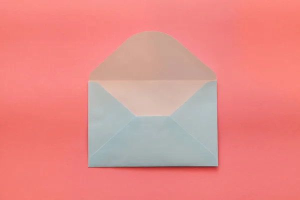 Blue envelope on a pink background. Flat lay concept for valentines day, womans day, wedding or birthday