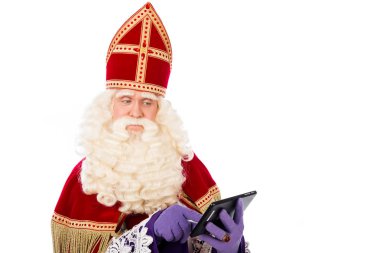 Saint Nicholas bakarak akıllı telefon veya elinde tablet. Beyaz arka plan üzerinde izole