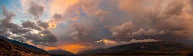 dramatik panorama gökyüzü ile thunderclouds ve günbatımı, dağlar