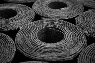 Yeni siyah çatı keçesi ya da bitumen Rolls of New Black 'in yakın çekimi. Yüzeyin derinliği