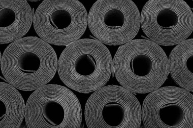 Yeni siyah çatı keçesi ya da bitumen Rolls of New Black 'in yakın çekimi. Yüzeyin derinliği