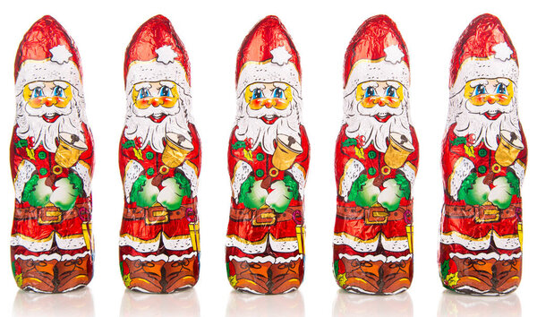Close-up of Santa Claus chocolate figures in a row. xmas Border Is on white background wit reflection