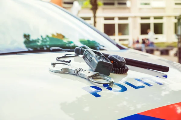 オランダ警察の装備。手錠、バトン、電話の上に — ストック写真