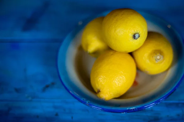 Four lemons on blue background — Stock Photo, Image