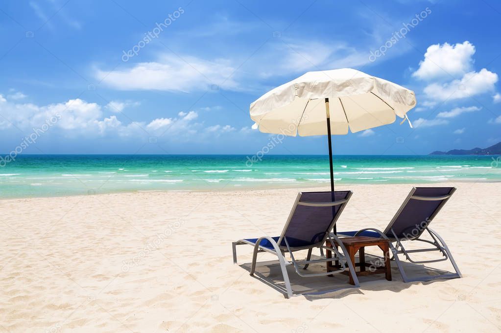 Beach chairs with umbrella and beautiful sand beach in Koh Samui, Thailand