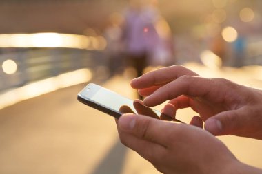 Adam cep telefonunu açık havada kullanıyor, kapat.