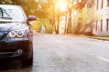 Arka sokakta asfalt yolda yeni siyah sedan otopark yakın çekim