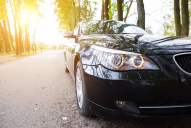 Arka sokakta asfalt yolda yeni siyah sedan otopark yakın çekim