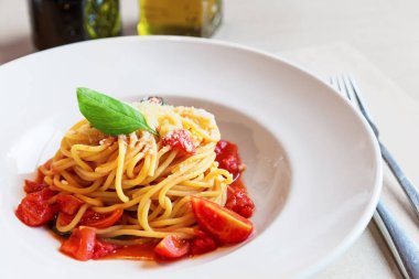 Spagetti makarna domates ve fesleğen yaprağı ahşap masa