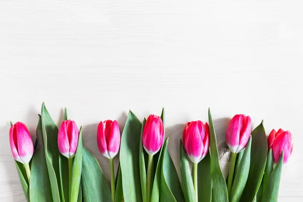 Krásné růžové tulipány na dřevěné pozadí — Stock fotografie