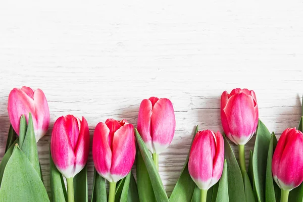 Krásné růžové tulipány na dřevěné pozadí — Stock fotografie
