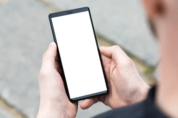 Man uses his Mobile Phone outdoor, close up.