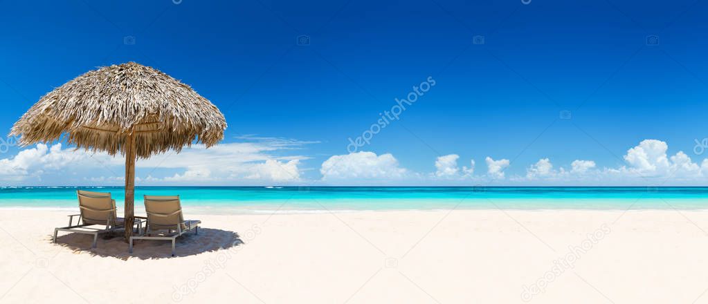 Beach chairs with umbrella and beautiful sand beach.