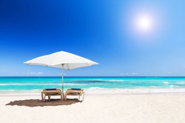 Beyaz şemsiyeli plaj sandalyeleri ve Punta Cana, Dominik Cumhuriyeti 'ndeki güzel kumsal plajı..