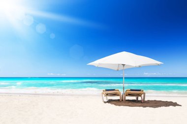 Beyaz şemsiyeli plaj sandalyeleri ve Punta Cana, Dominik Cumhuriyeti 'ndeki güzel kumsal plajı..