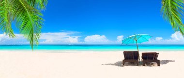 Dominik Cumhuriyeti, Punta Cana 'da şemsiyeli plaj sandalyeleri ve güzel kumsallar. Beyaz kum ve turkuaz suyu olan tropik plaj manzarası. Seyahat yaz tatili kavramı.